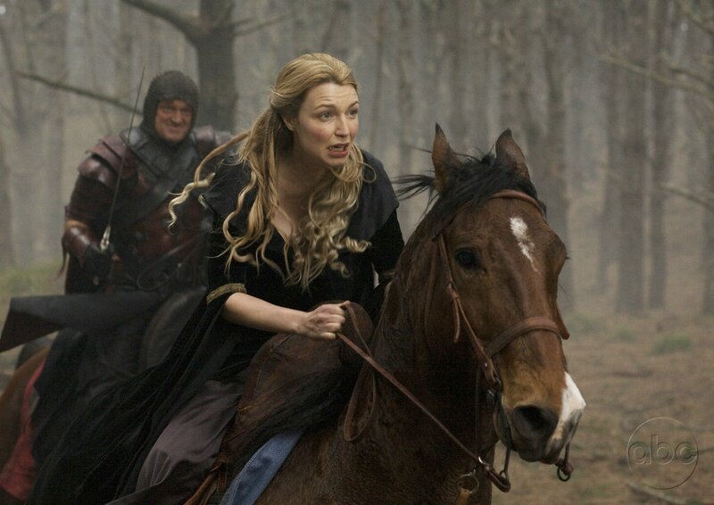 Woman riding horse in forest