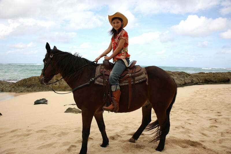 Woman riding horse on beach
