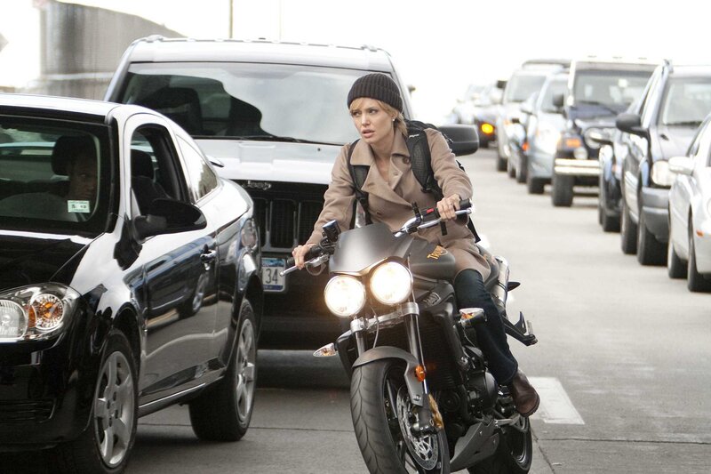 Woman riding motorcycle in traffic