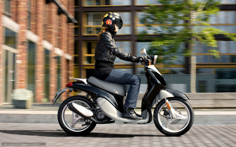 Woman riding scooter in city