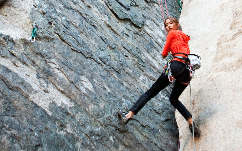 Woman rock climbing on a cliff