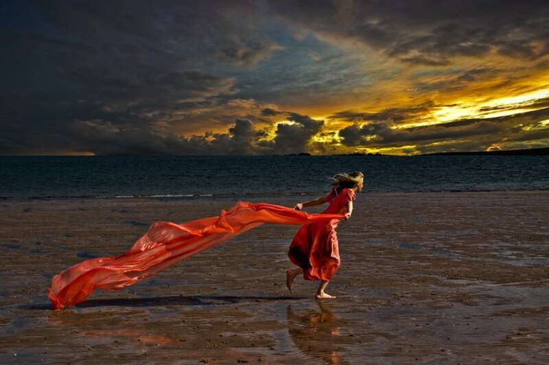 Woman running on beach at sunset