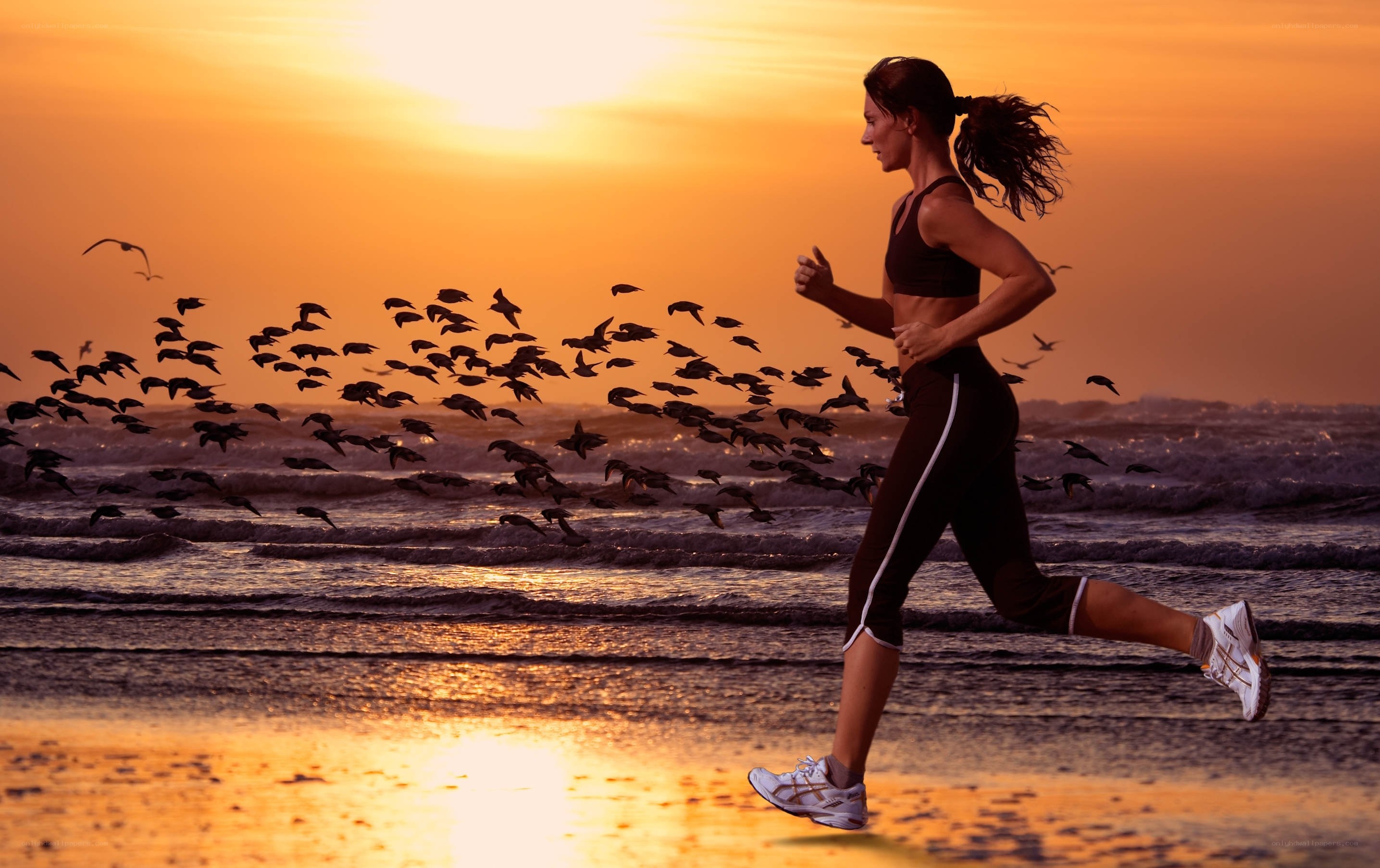 woman running on beach at sunset