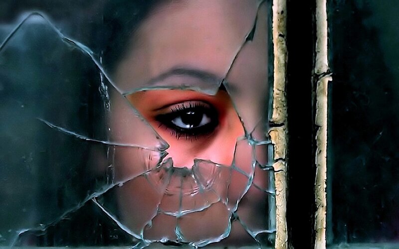 Woman's Eye Through Broken Glass