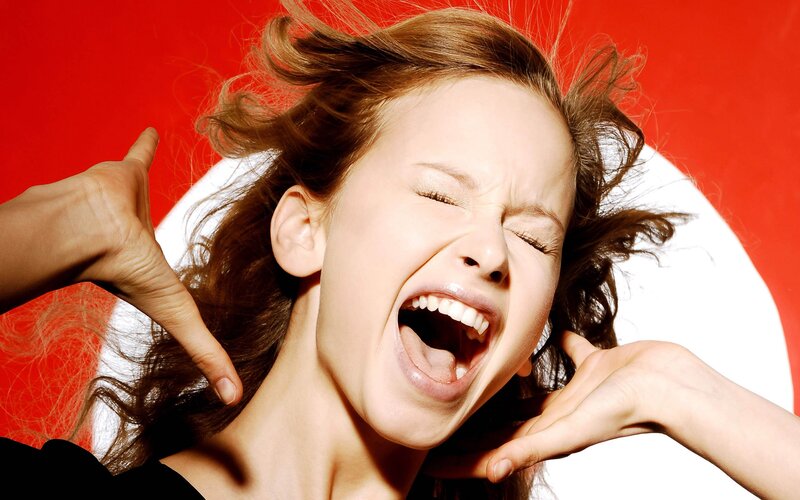 woman screaming with hands on face