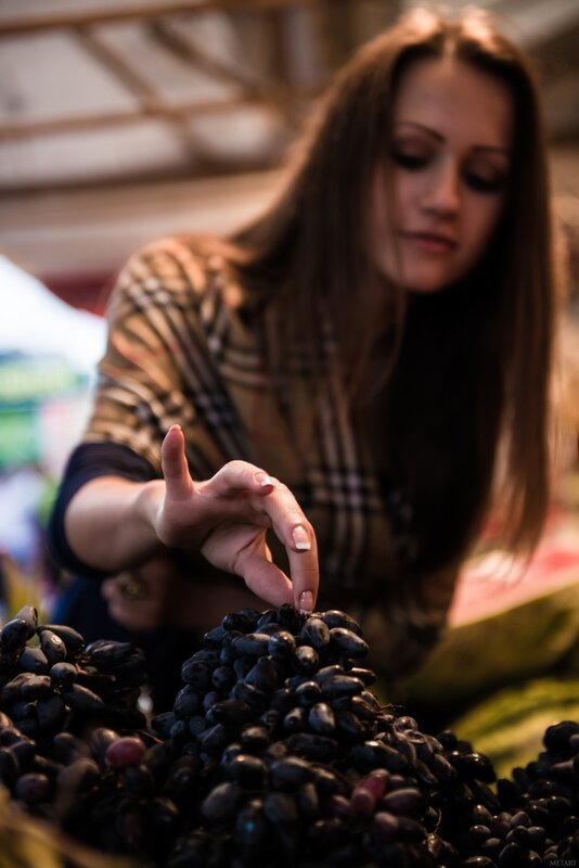 woman selecting grapes at market