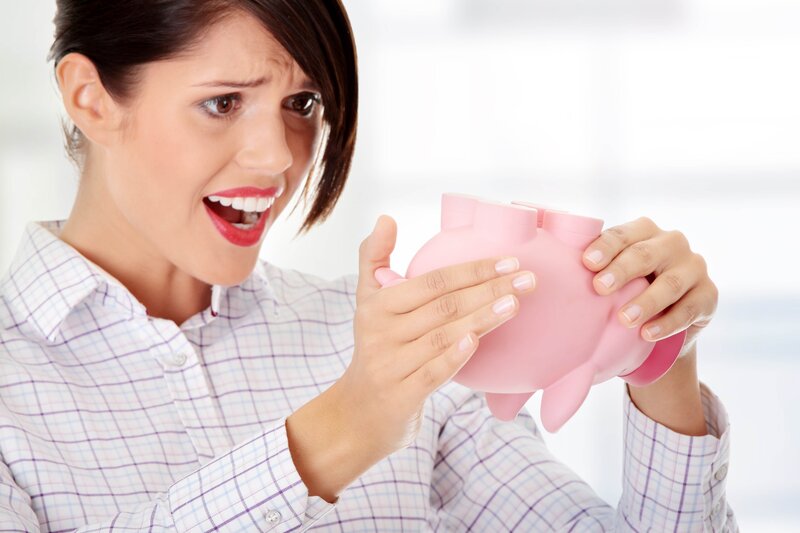 woman shaking piggy bank