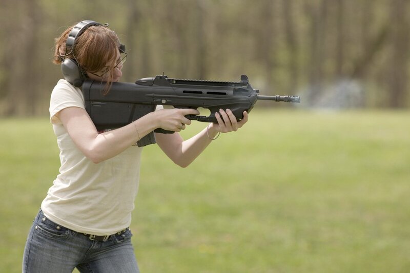 woman shooting rifle at range