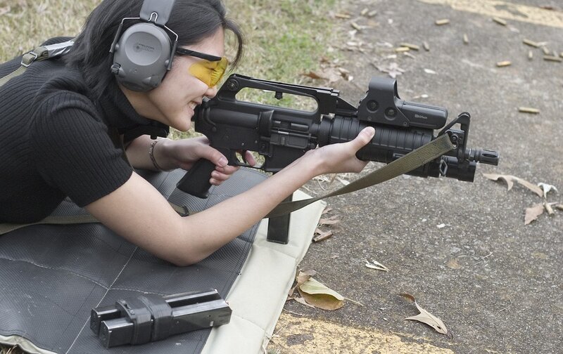 Woman shooting rifle at range