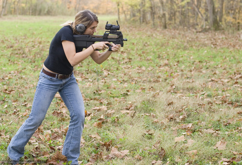 woman shooting rifle in field