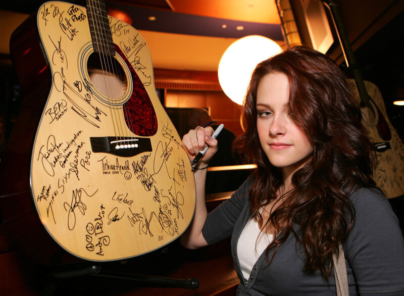 woman signing a guitar