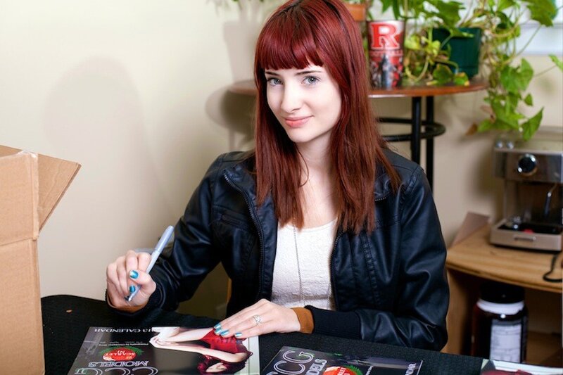 woman signing a magazine