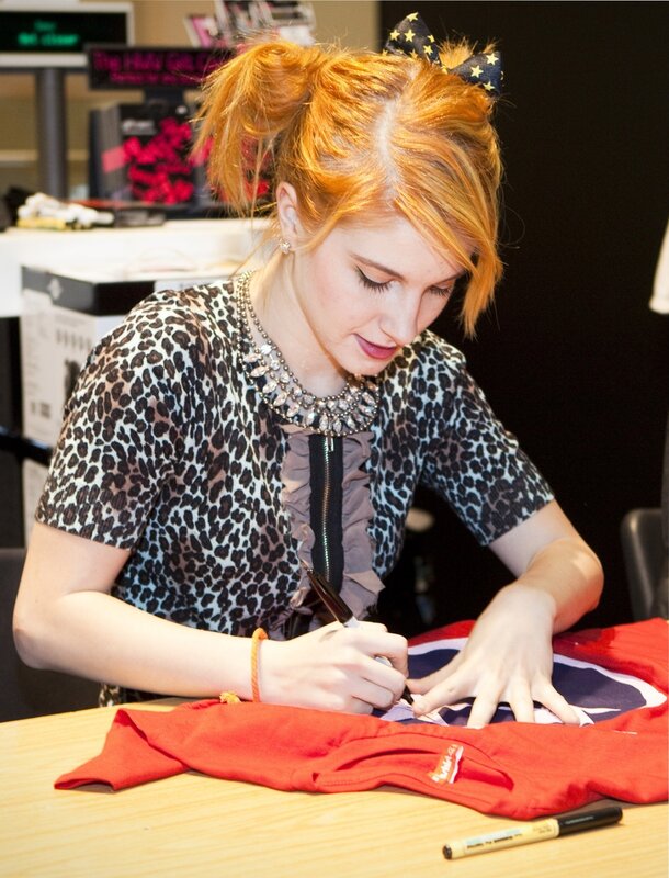 woman signing a t-shirt