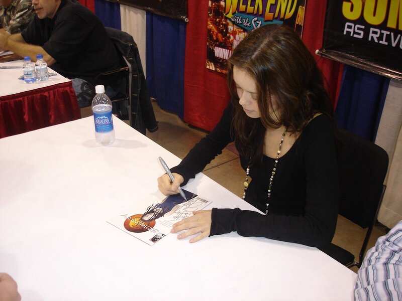 woman signing autograph at convention