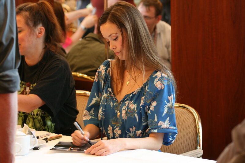 woman signing autograph at event