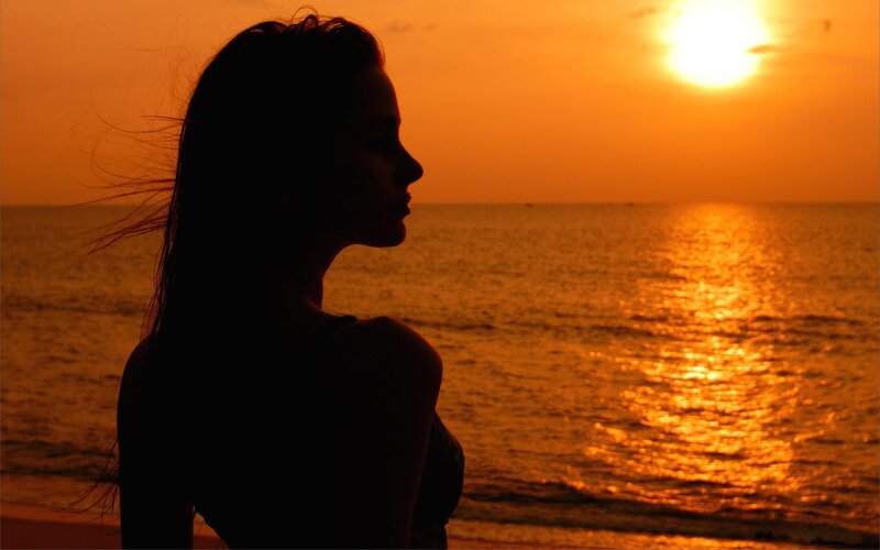 woman silhouetted at sunset