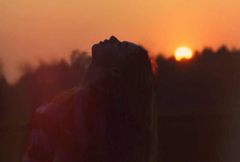 woman silhouetted at sunset
