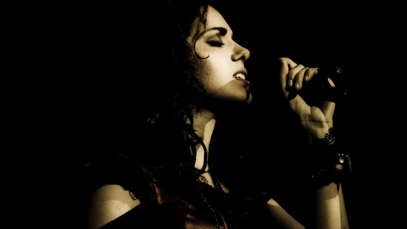 Woman Singing into Microphone — Black, Dramatic, Night, Photograph, Curly Hair