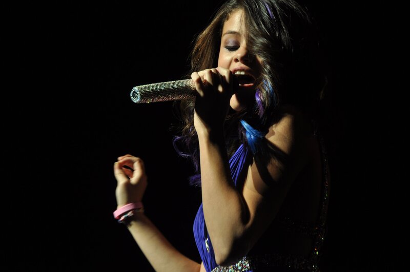 Woman Singing into Microphone — Black, Dramatic, Night, Photograph, Stage Light, Dress, Blue