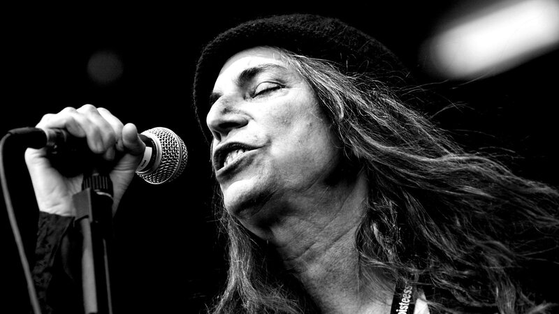 Woman Singing into Microphone — Black, Dramatic, Photograph, Hat
