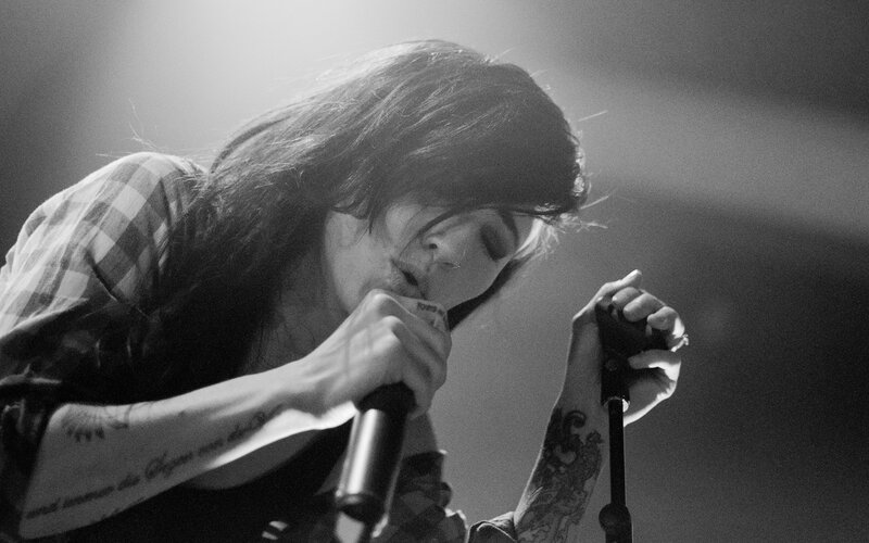 Woman Singing into Microphone — Black, Dramatic, Photograph, Tattoos