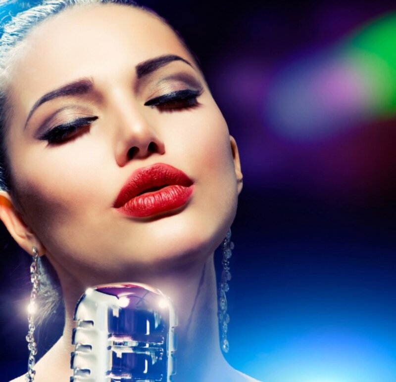 Woman Singing into Microphone — Blue, Dramatic, Night, Photograph, Earrings