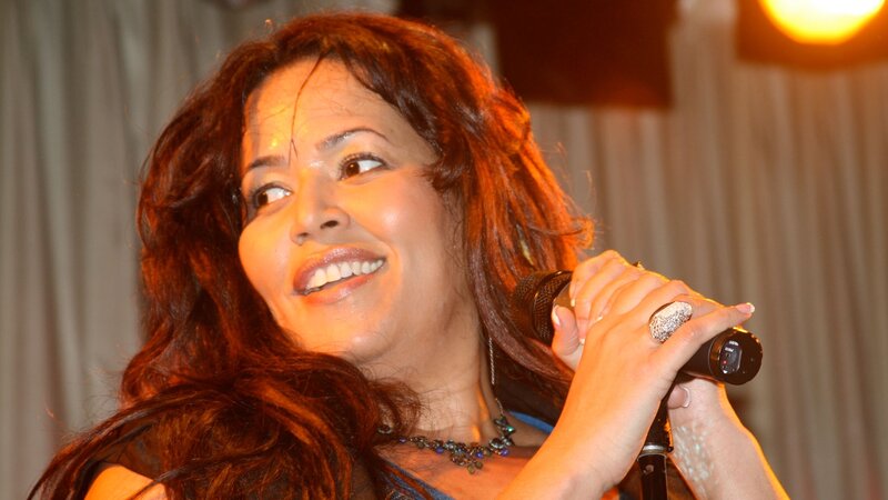 Woman Singing into Microphone — Brown, Lively