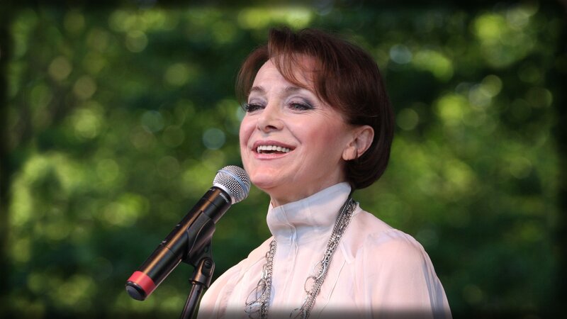 Woman Singing into Microphone — Green, Outdoor