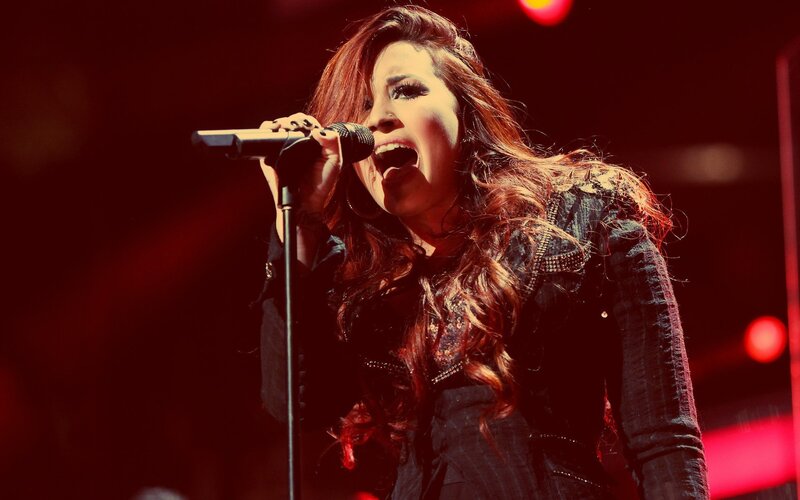 Woman Singing into Microphone — Red, Dramatic, Photograph, Stage Lights, Jacket