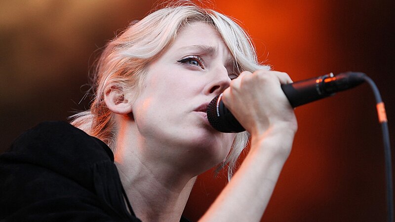 Woman Singing into Microphone — Red, Intense, Photograph