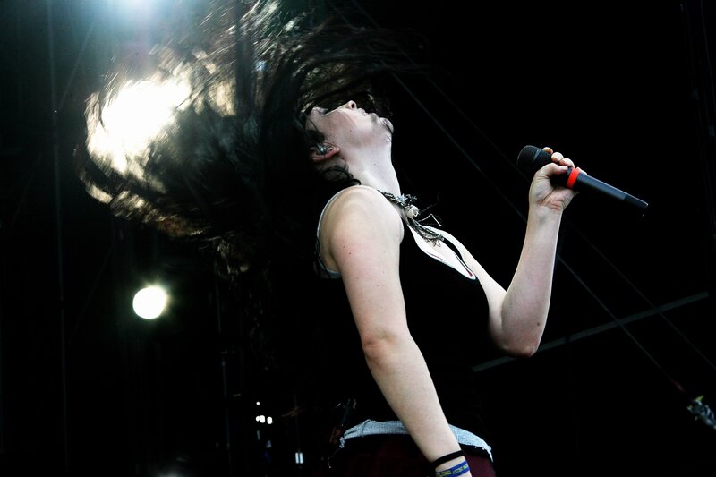 Woman Singing on Stage — Black, Dramatic, Night, Photograph, Microphone, Hair