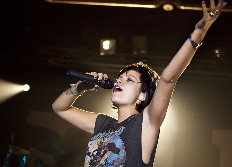 Woman Singing on Stage — Black, Dramatic, Night, Photograph, Microphone, Stage Lights, Tattoo, White