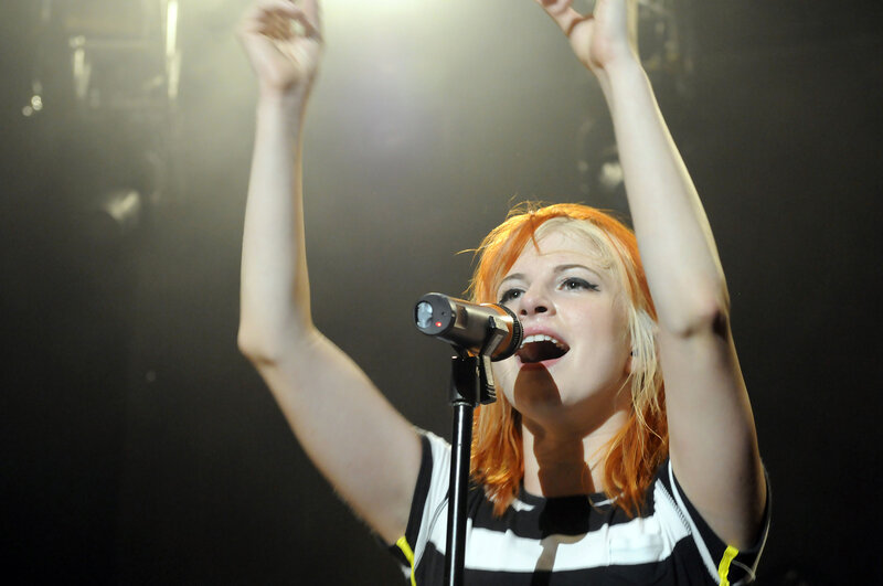 Woman Singing on Stage — Black, Energetic, Night, Photograph, Microphone, Arms Raised