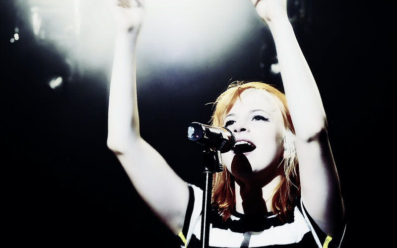 Woman Singing on Stage — Black, Energetic, Night, Photograph, Microphone, Stage Lights, Arms Raised