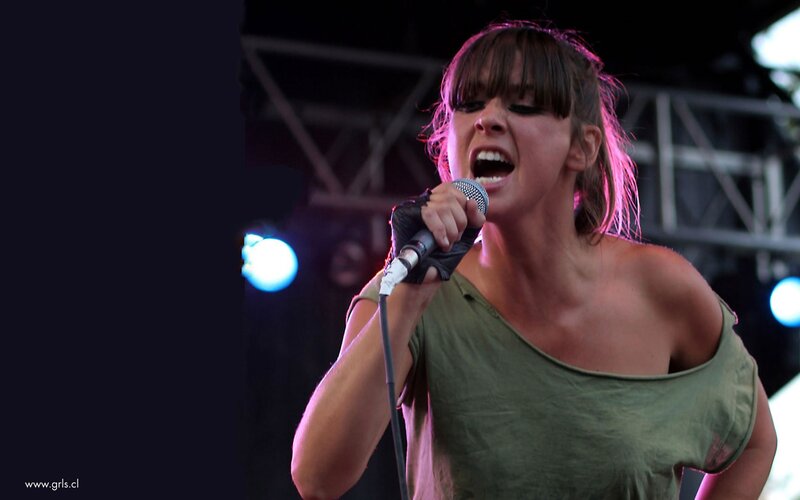 Woman Singing on Stage — Green, Energetic, Night, Photograph, Microphone, Stage Lights, Guitar Strap