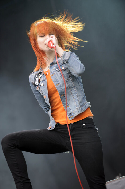 Woman Singing on Stage — Orange, Energetic, Photograph, Microphone, Denim Jacket, Black