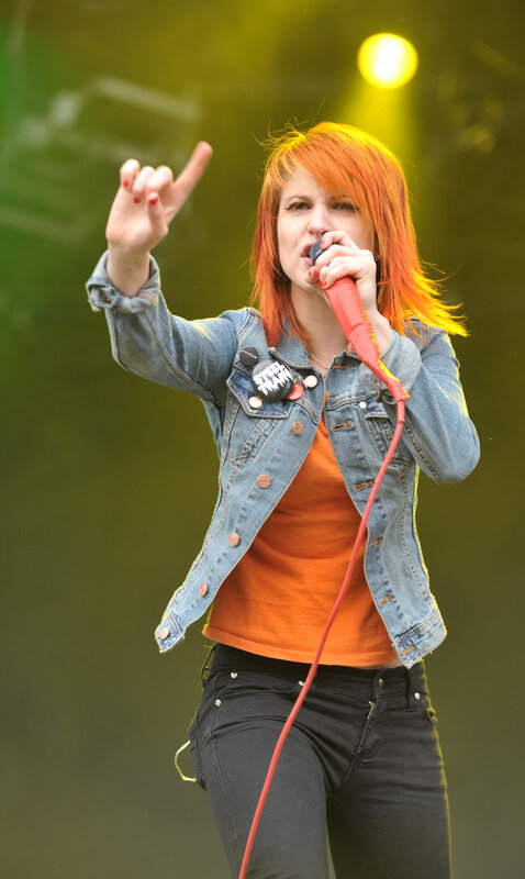 Woman Singing on Stage — Orange, Energetic, Photograph, Microphone, Denim Jacket, Stage Light, Blue