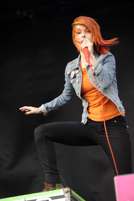 Woman Singing on Stage — Orange, Energetic, Photograph, Microphone, Jeans Jacket