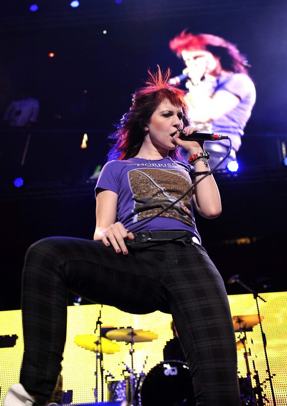 Woman Singing on Stage — Purple, Energetic, Night, Photograph, Microphone, Drum Kit, Screen
