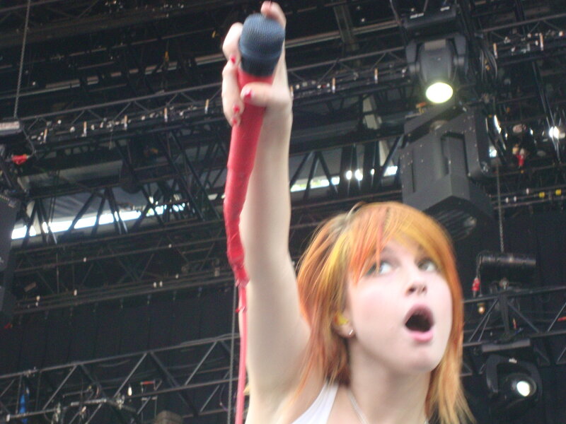 Woman Singing on Stage — Red, Energetic, Afternoon, Photograph, Microphone, Stage Lights