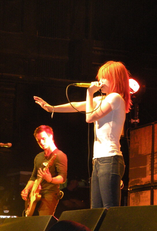 Woman Singing on Stage — Red, Energetic, Night, Photograph, Man Playing Guitar