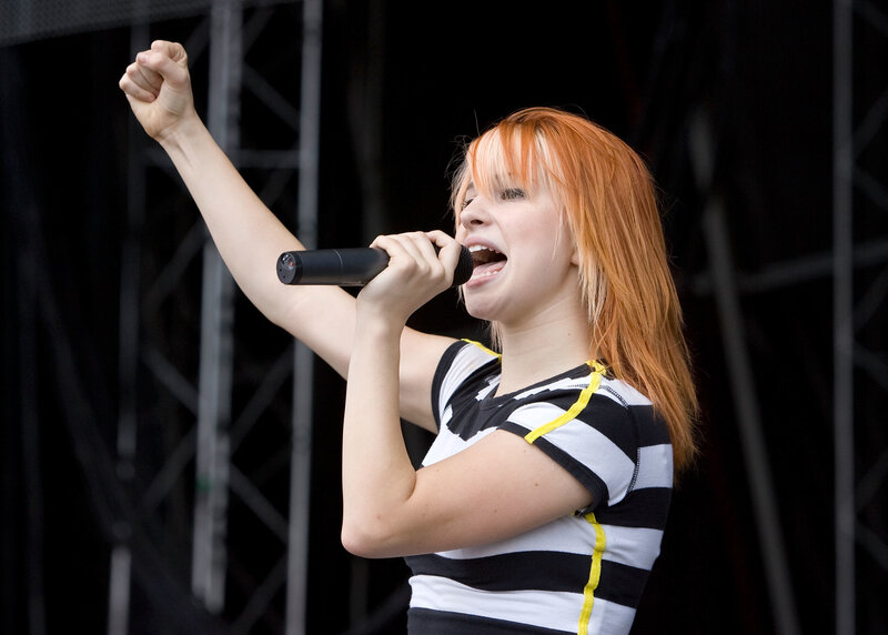 Woman Singing on Stage — Red, Energetic, Photograph, Microphone, Hair