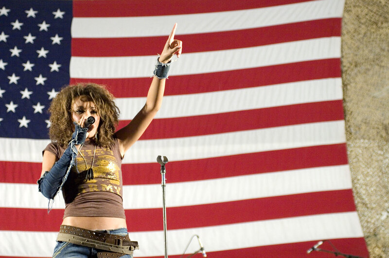 Woman singing on stage with American flag