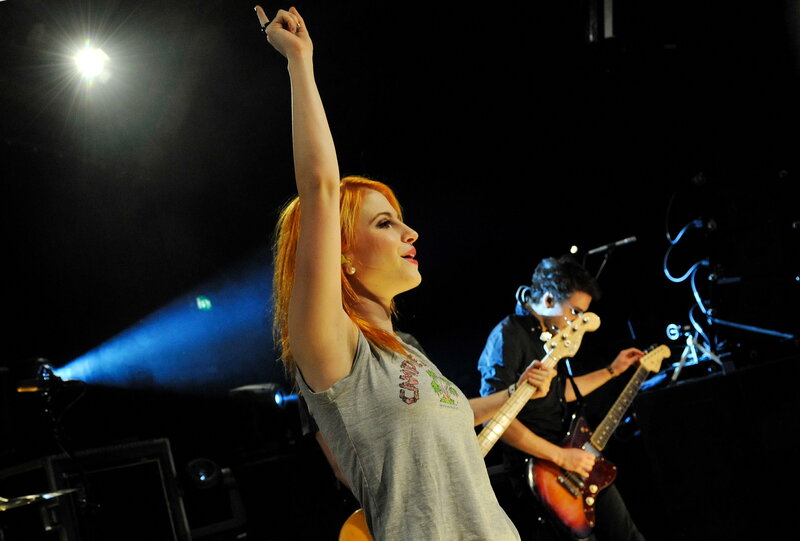 Woman singing on stage with band