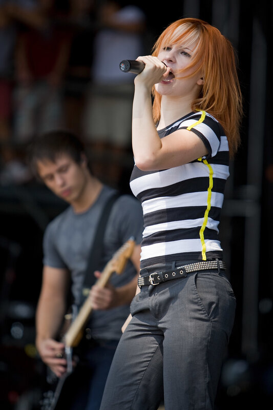 Woman singing on stage with band