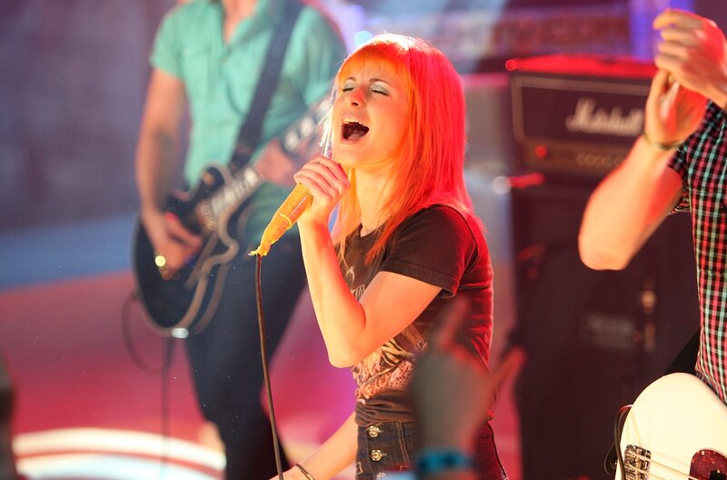 Woman singing on stage with band