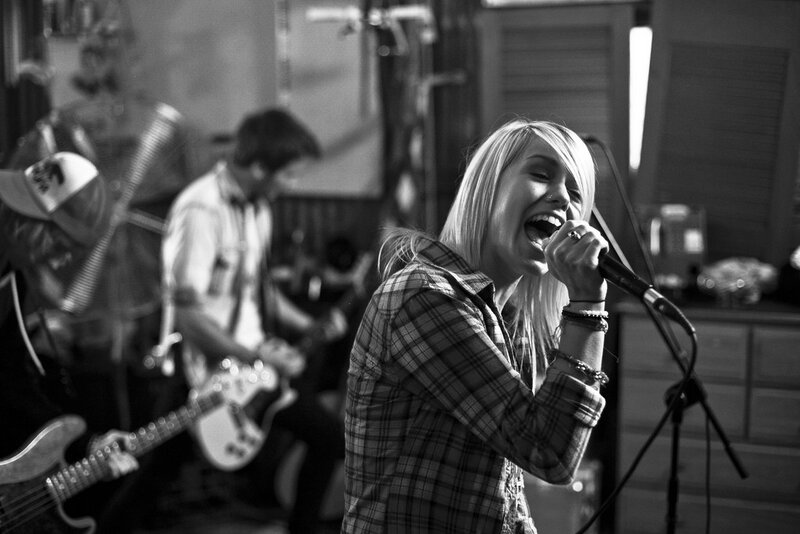 woman singing on stage with band