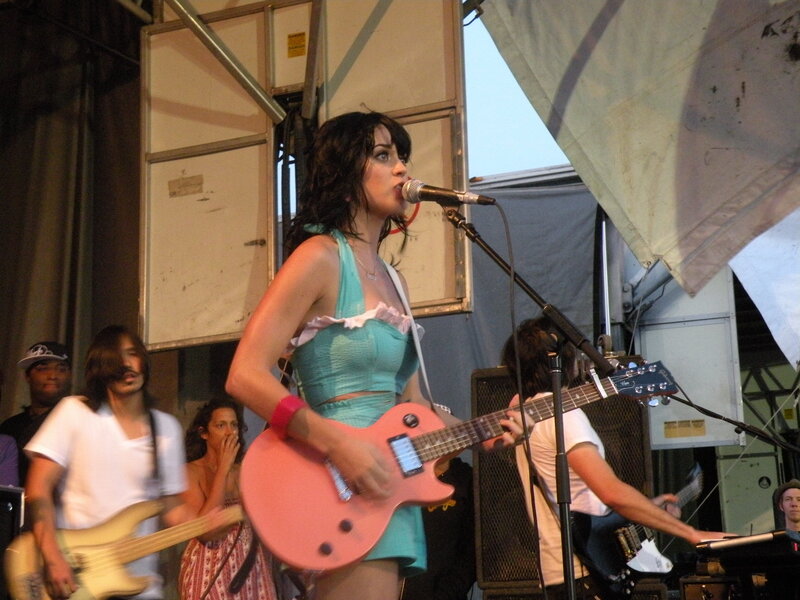 Woman singing on stage with guitar