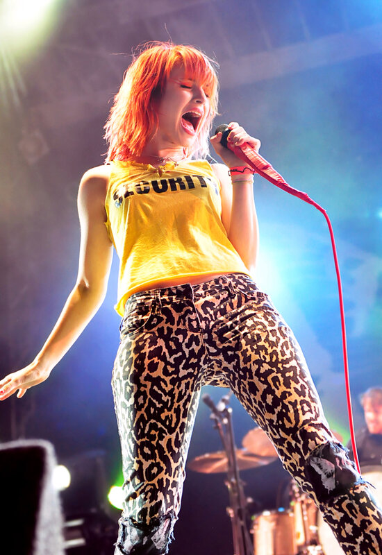Woman Singing on Stage — Yellow, Energetic, Night, Photograph, Microphone, Stage Lights