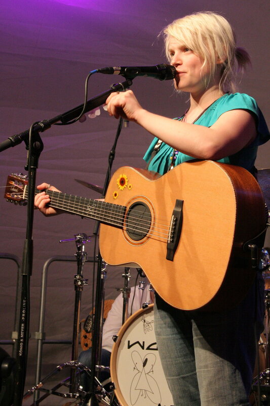Woman singing with acoustic guitar